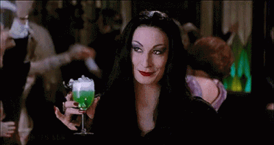 Morticia Addams with a smoking, acid-green drink in-hand